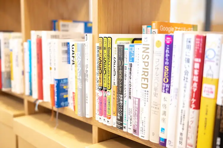 マーケティングやデザイン、ビジネス関連の書籍が並ぶオフィス内の本棚