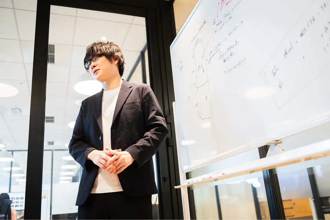 ホワイトボードを使って説明をしているビジネスパーソン