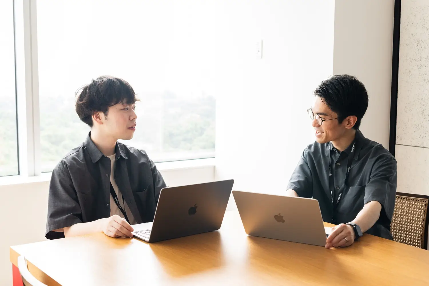 2人のビジネスマンが向き合って議論する様子
