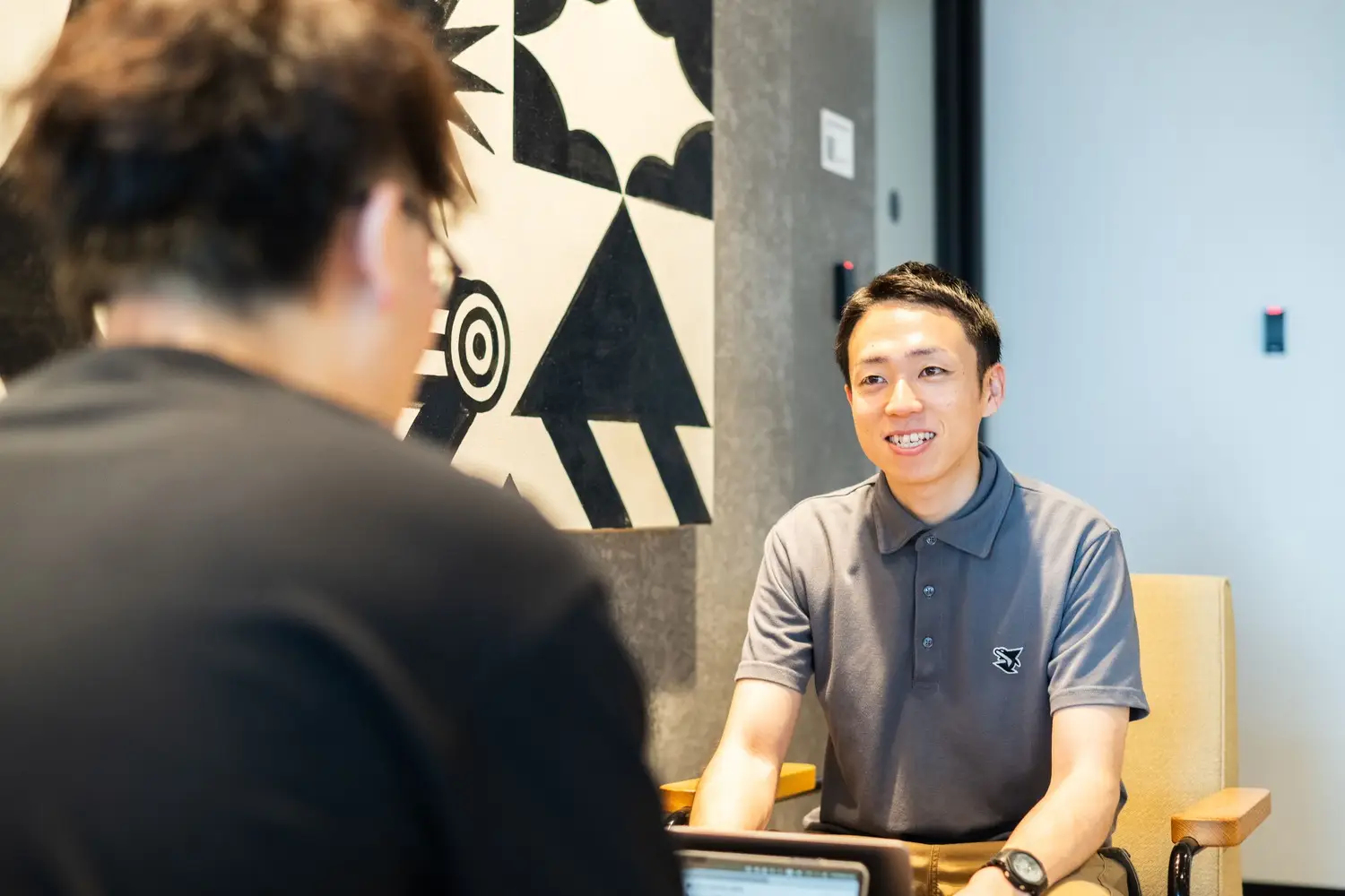 共用ラウンジで1on1をする男性社員の様子