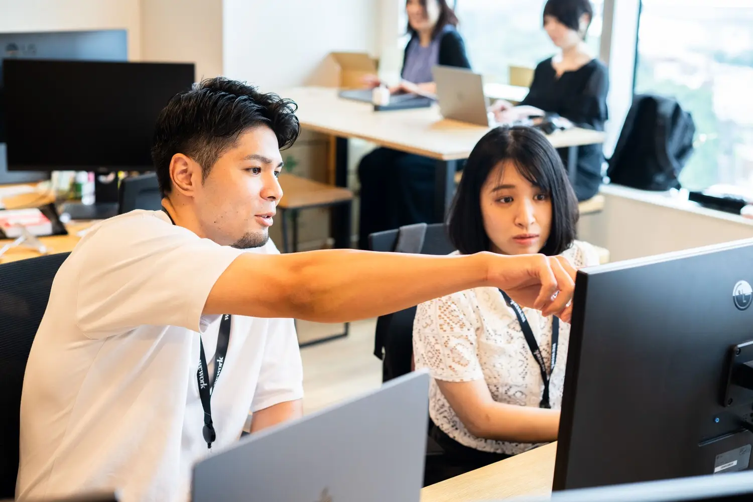隣に座っている社員に教える様子