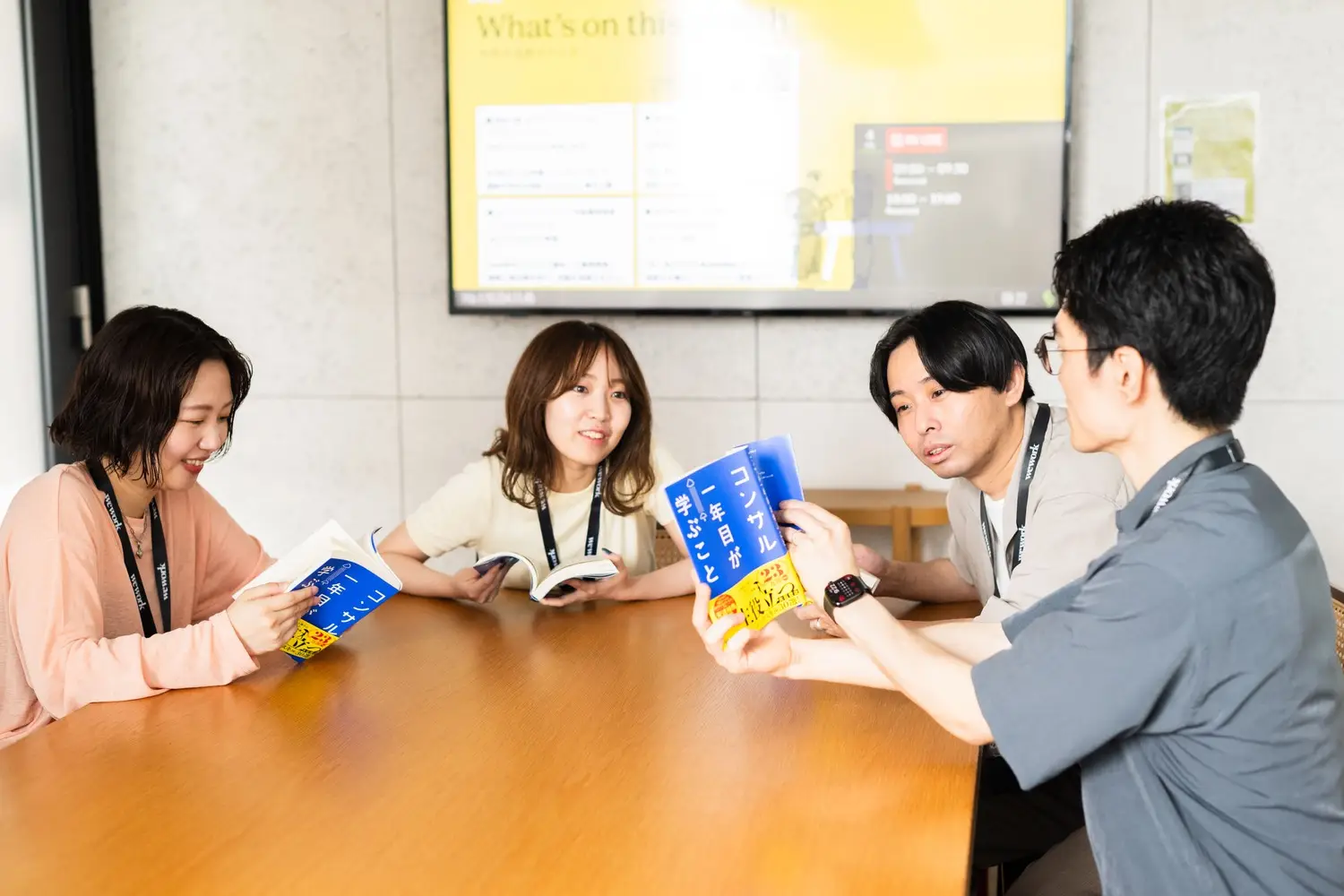 4人が会議室で輪読会をする様子