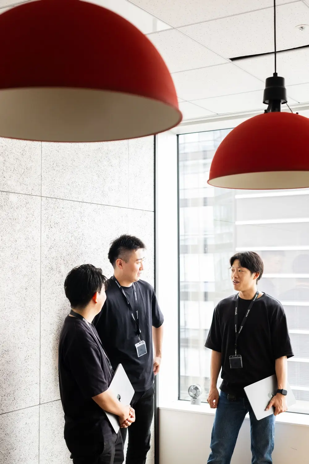 会議室で立ちながら会話をしている男性社員