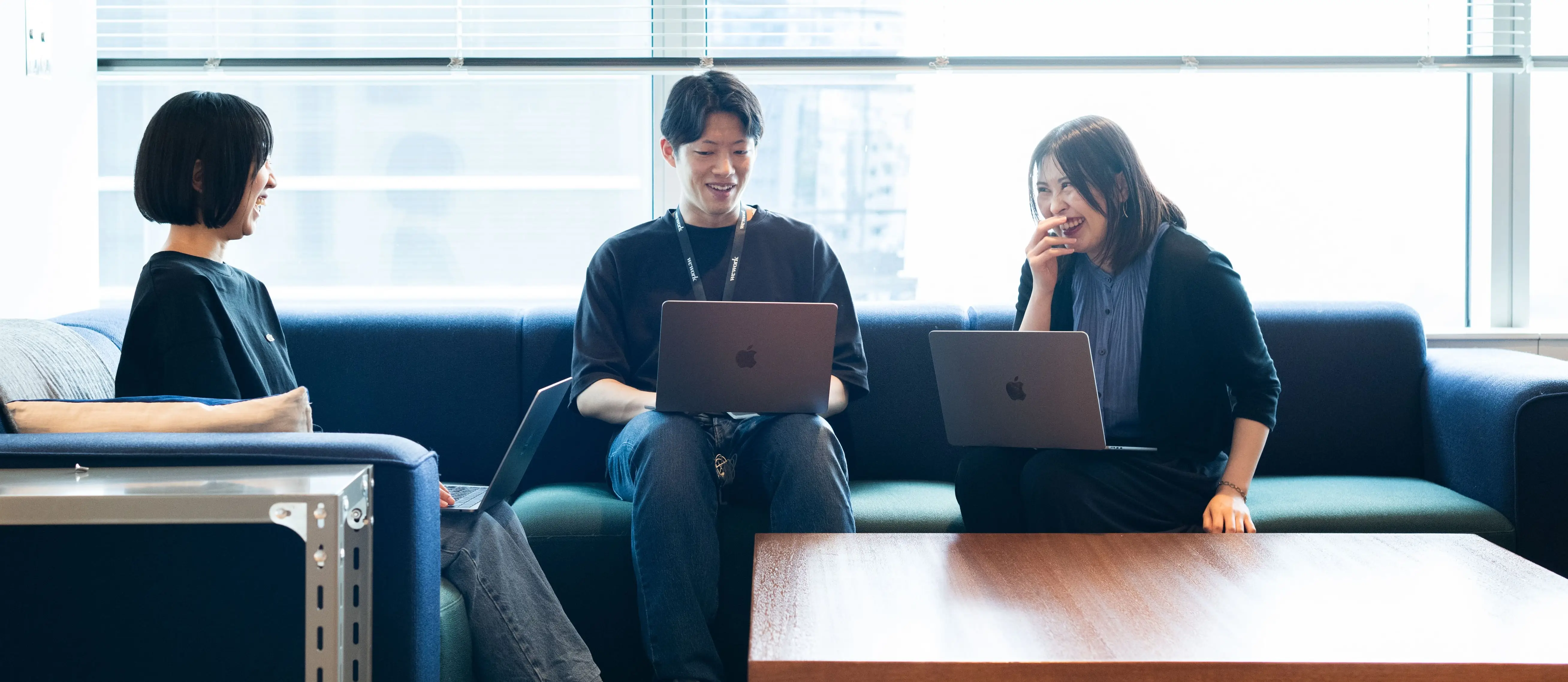 共用ラウンジのソファで談笑をする社員たち