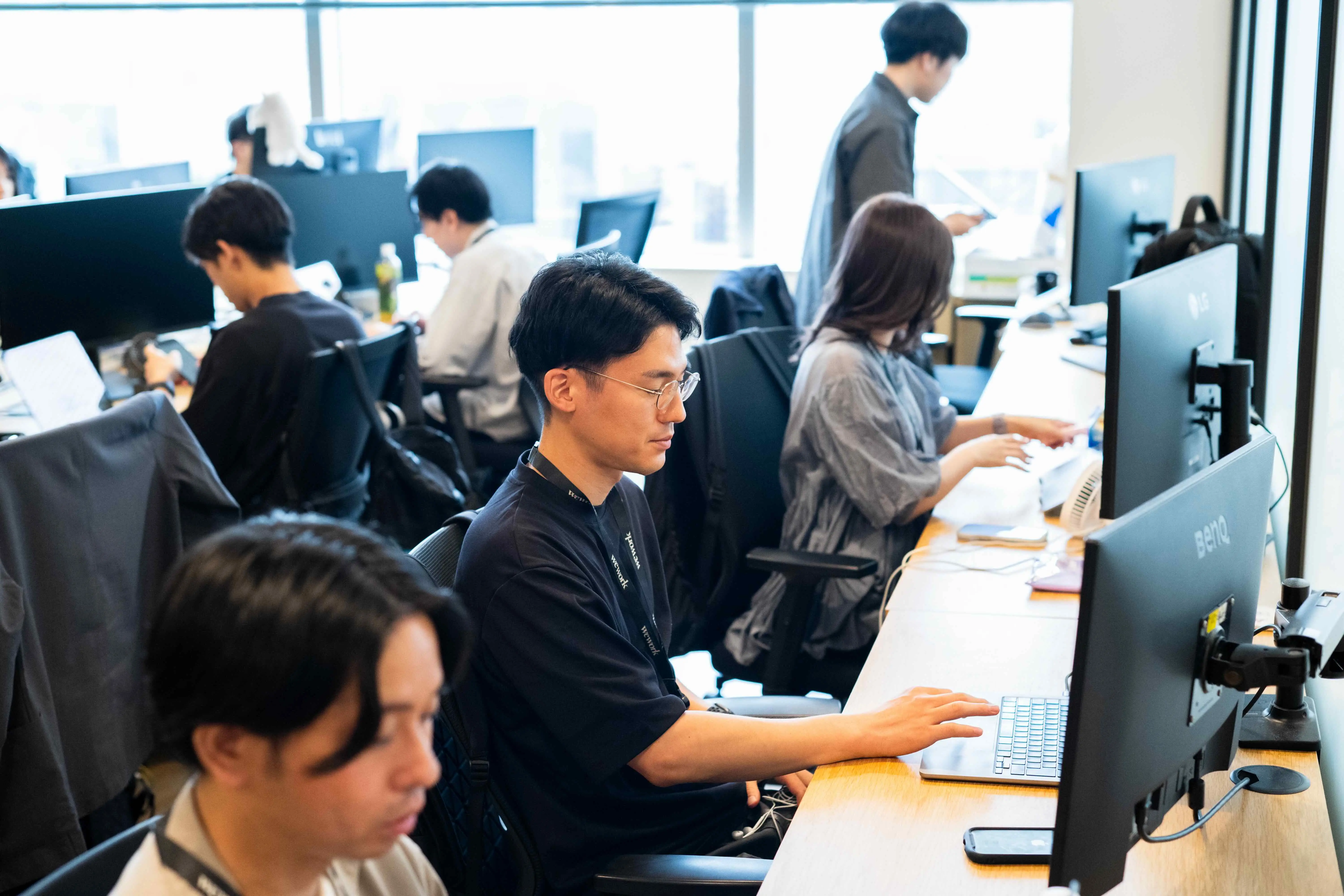 オフィススペースで向かい合って作業をする社員たちの様子