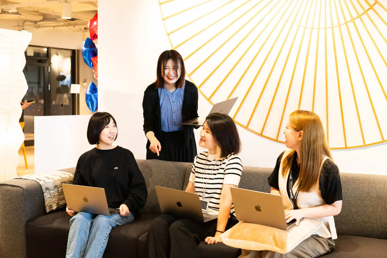 共用ラウンジのソファで談笑する女性社員