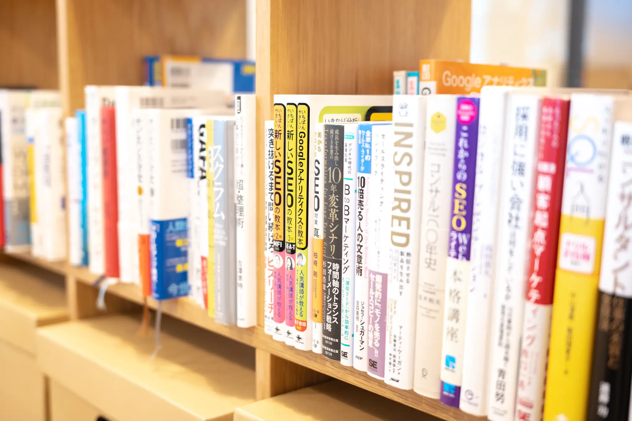 マーケティングやデザイン、ビジネス関連の書籍が並ぶオフィス内の本棚